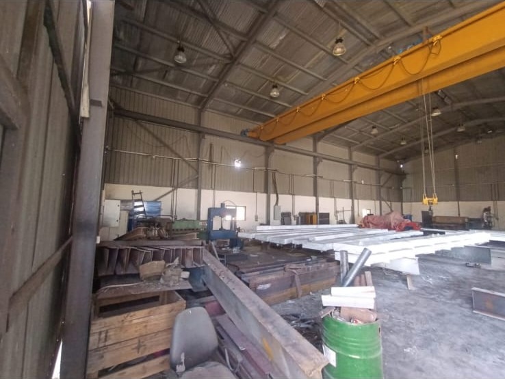 مصنع الحديد في وادي العش مع رافعة جسرية علوية وقطاعات مجهزة — E&M steel fabrication workshop with overhead gantry crane