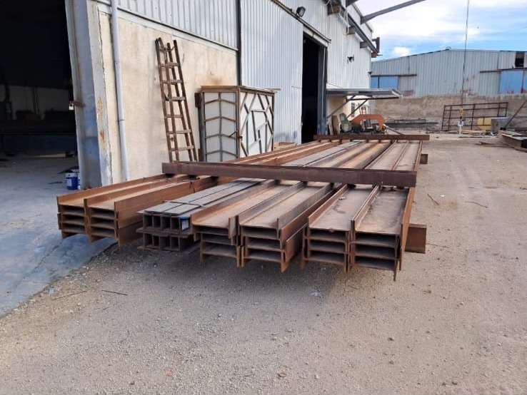 جوائز حديدية مصنّعة جاهزة للنقل من مصنع E&M — fabricated steel beams ready for dispatch from the E&M factory