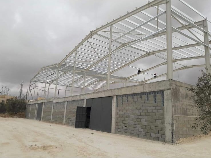 Curved structural steel roof frame erected by E&M over a concrete block structure