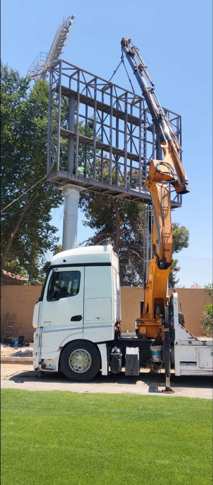 Truck-mounted crane erecting a steel structure frame