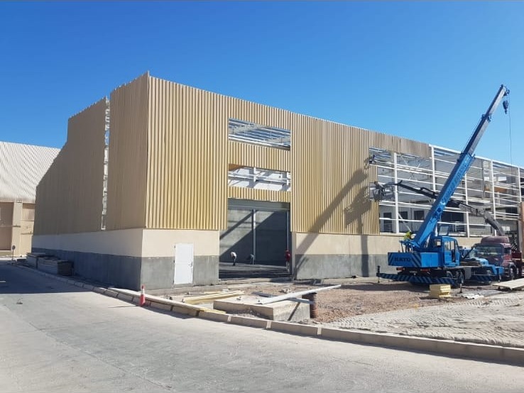 تركيب الكسوة المعدنية لهيكل حديدي بمساعدة رافعة في مشروع E&M — metal cladding installation on a steel frame by E&M